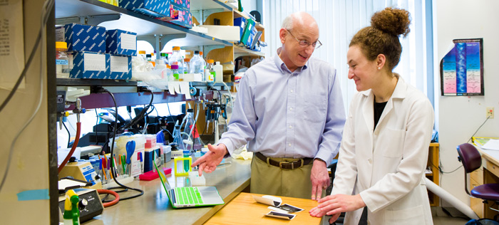 Professor and student at lab bench talking