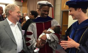 Student at graduation with baby