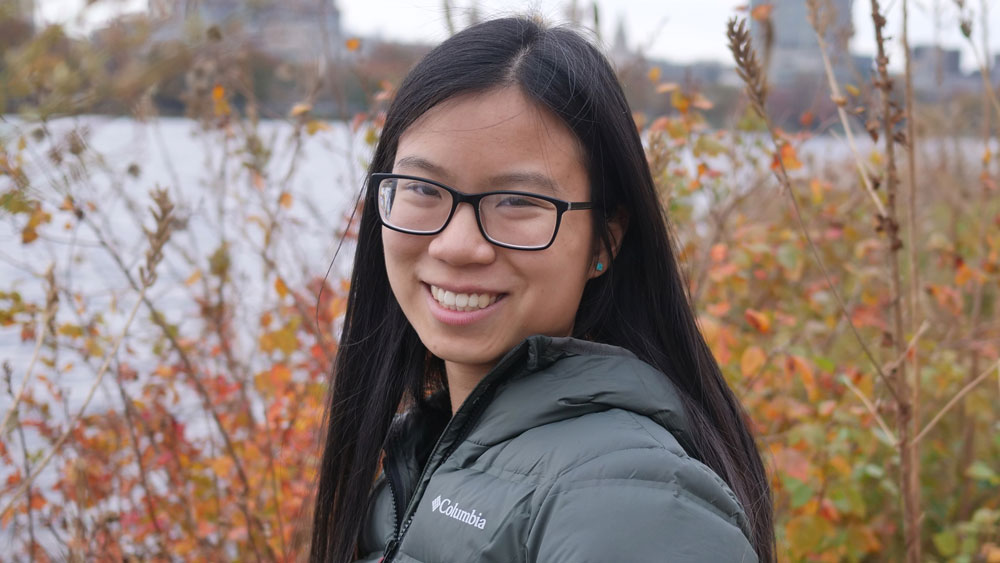 Person smiling in front of river